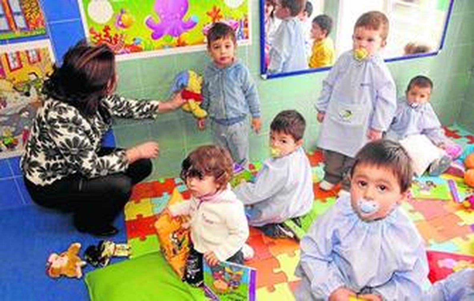 La consejera atiende a uno de los niños de la guardería La Cometa.