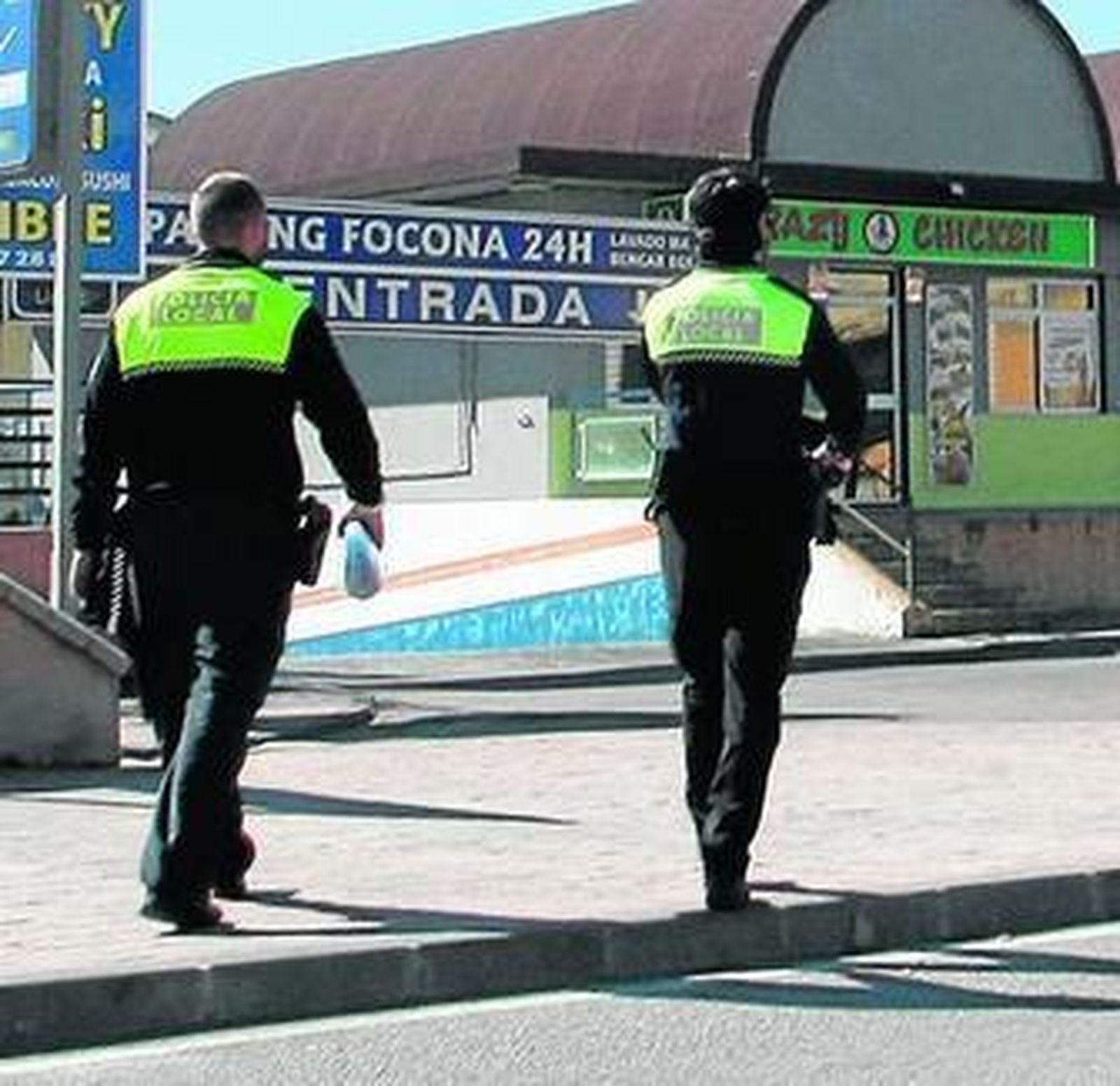 Dos agentes locales caminan por una callen de La Línea.
