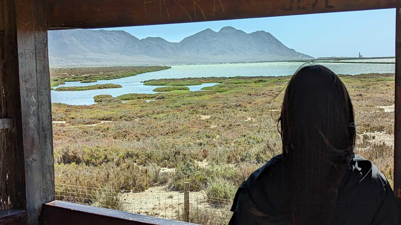 Una joven aprecia las visitas de Las Salinas de Cabo de Gata desde el mirador.