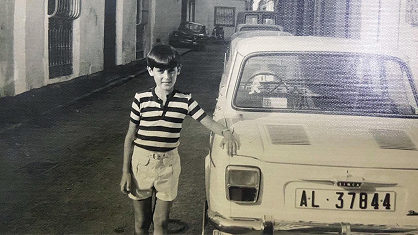 Un niño de la calle Marcos junto a un coche recién matriculado, en el verano de 1970