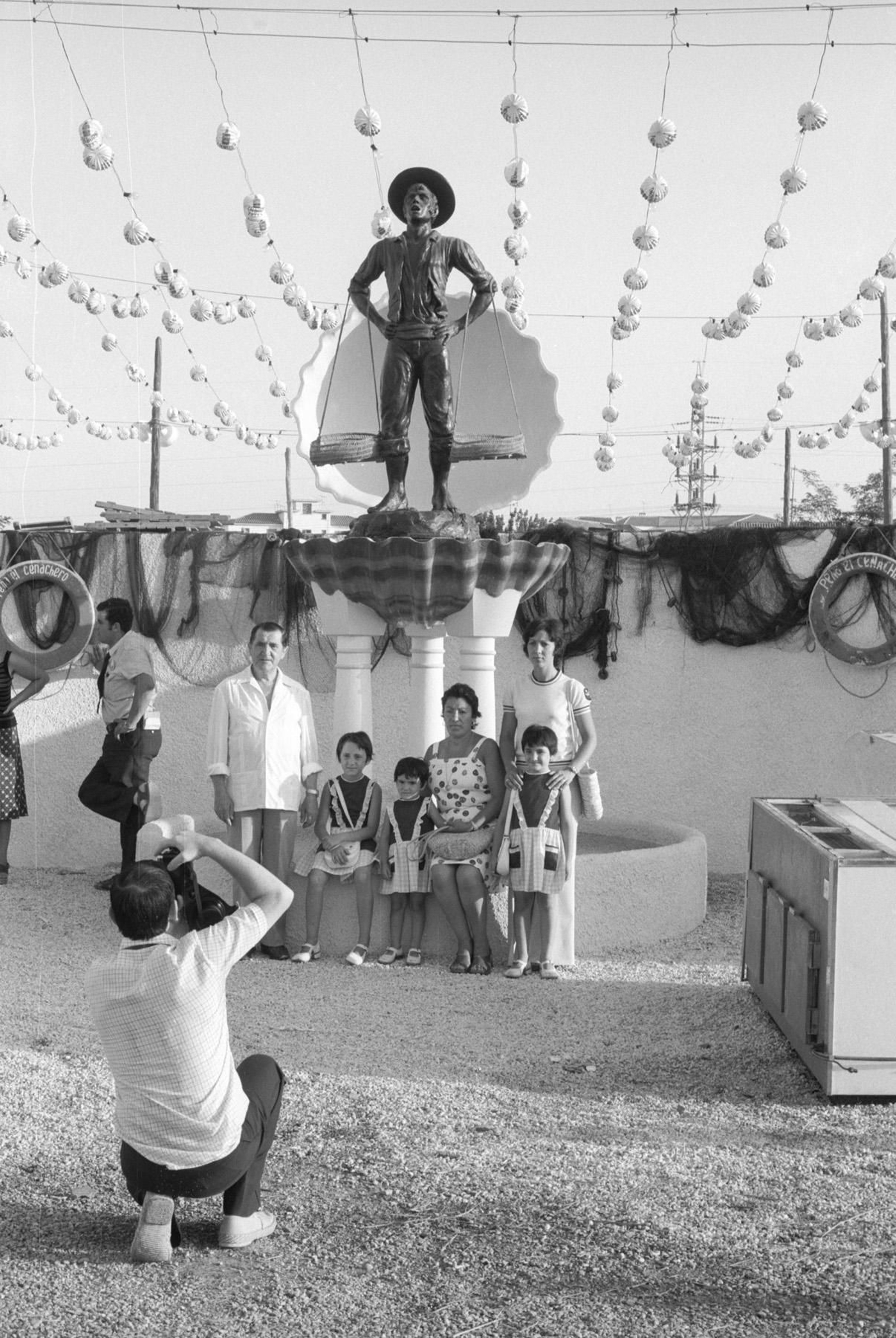 Una familia posa con la estatua del