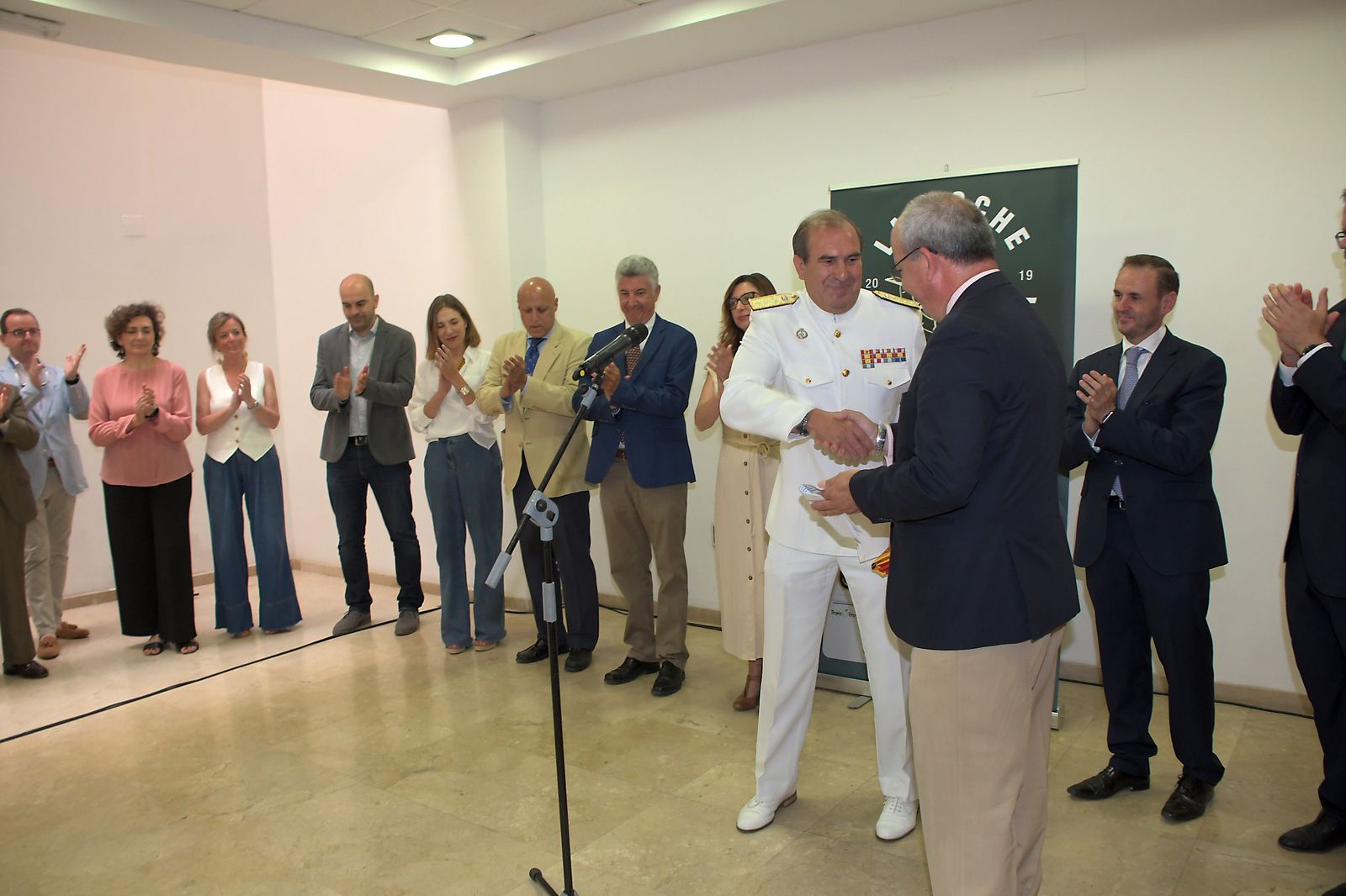 avier Sánchez Rojas hace entrega de una bandera de España al almirante del Arsenal de Cádiz, Enrique Torres, en Cádiz, en la sede de la CEC.