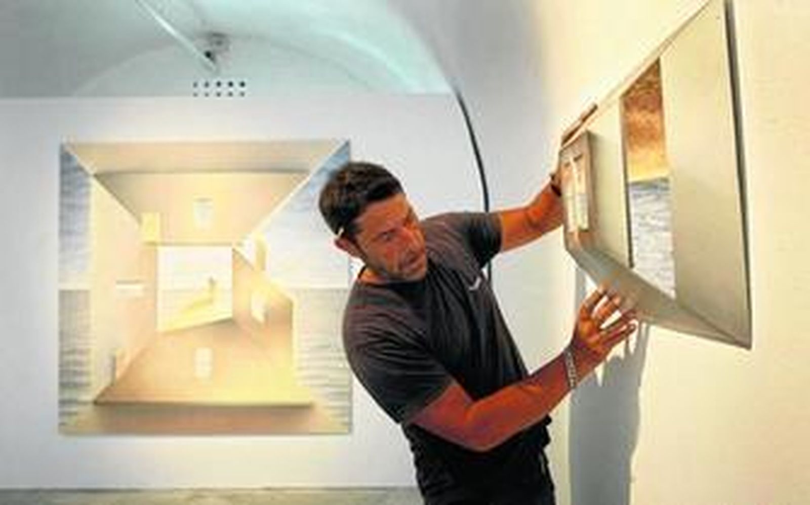 Un operario coloca uno de los cuadros que integran la Eccolección.