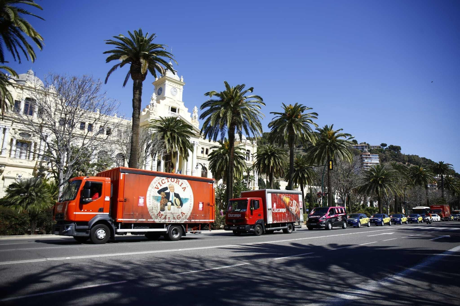 La caravana de vehículos pasa por el Paseo del Parque, frente a la sede del Ayuntamiento de Málaga.