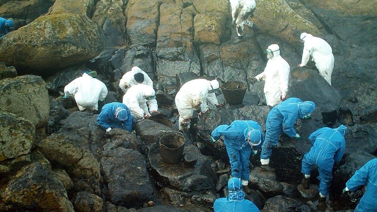 Cadena humana en el acantilado para retirar chapapote.