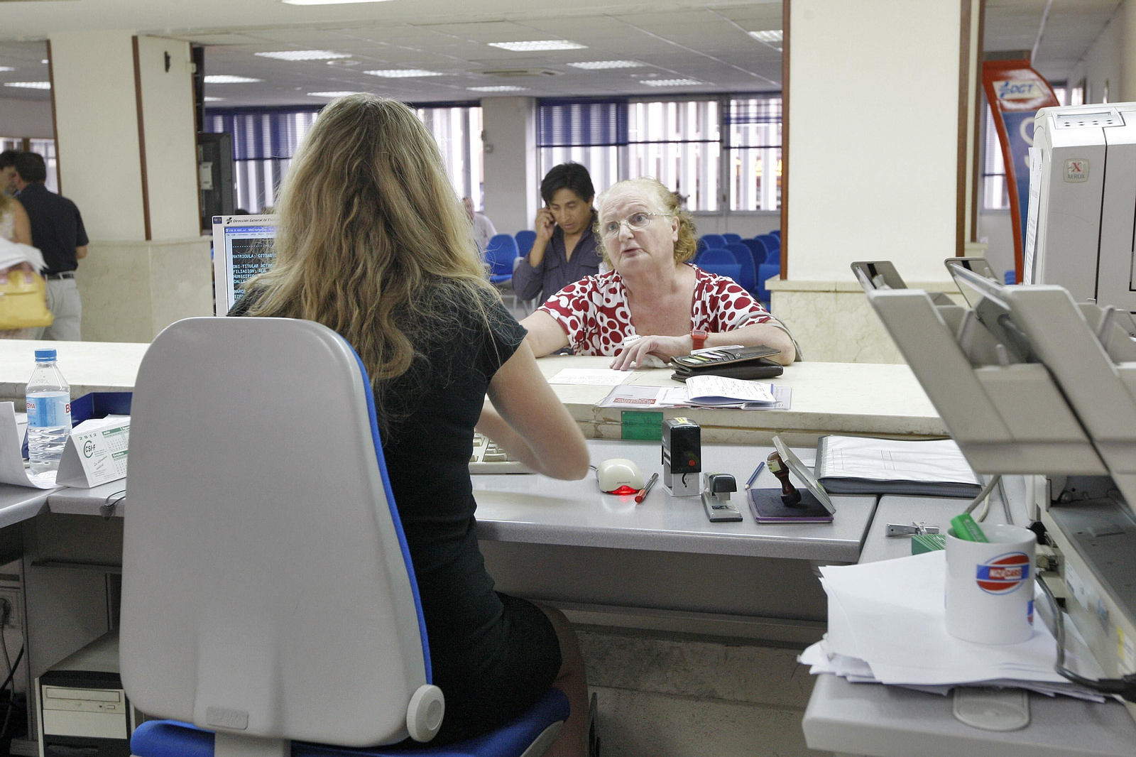 Una oficinista atiende a una ciudadana.