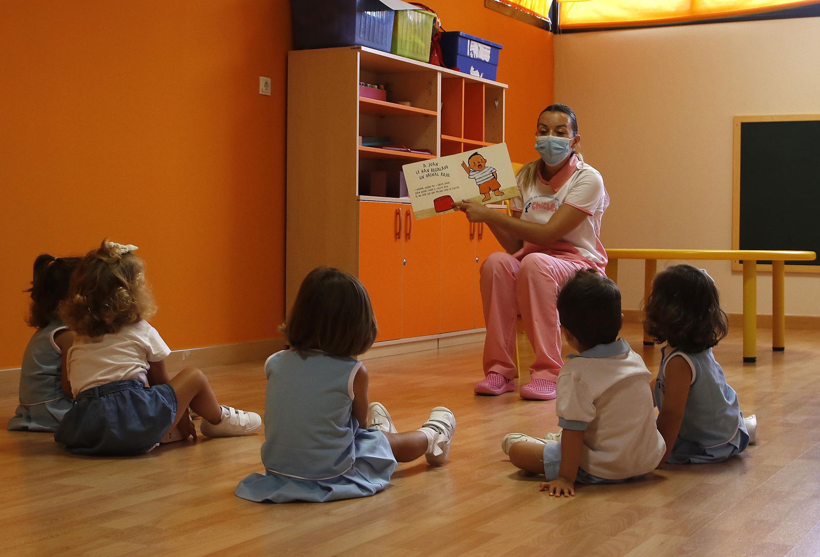 Pequeños en la guardería durante una sesión de lectura.