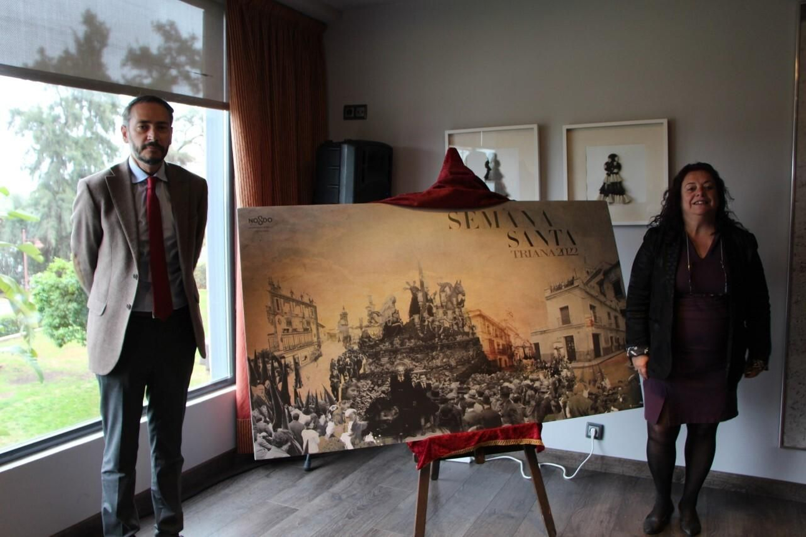 Santi León y Encarnación Aguilar junto al cartel de la Semana Santa de Triana 2022.