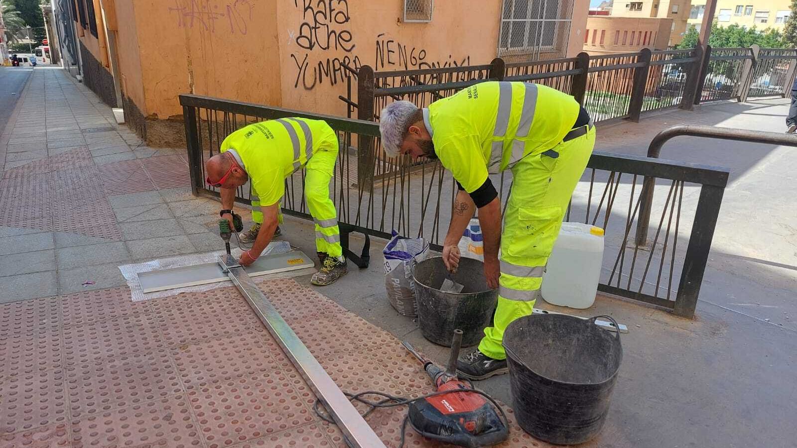 Operarios colocando la placa en la pasarela de Pescadería a Plaza Pavía.