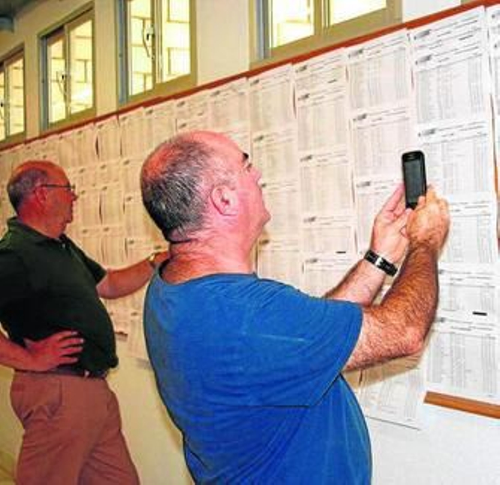 Unos padres revisan las notas de selectividad.