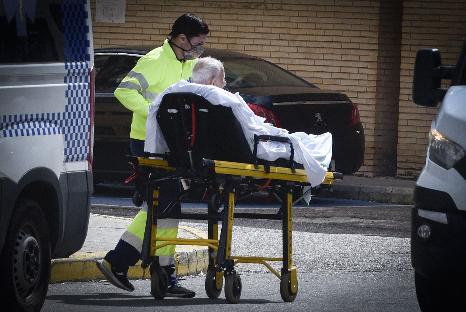 Un paciente es trasladado en camilla por un profesional sanitario.