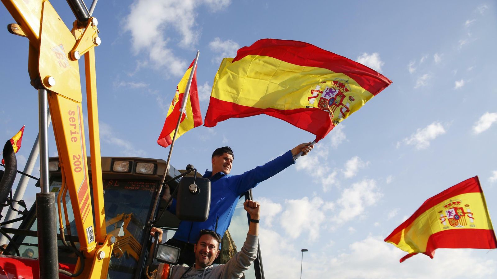 Un joven agricultor ondea una bandera española durante la marcha.