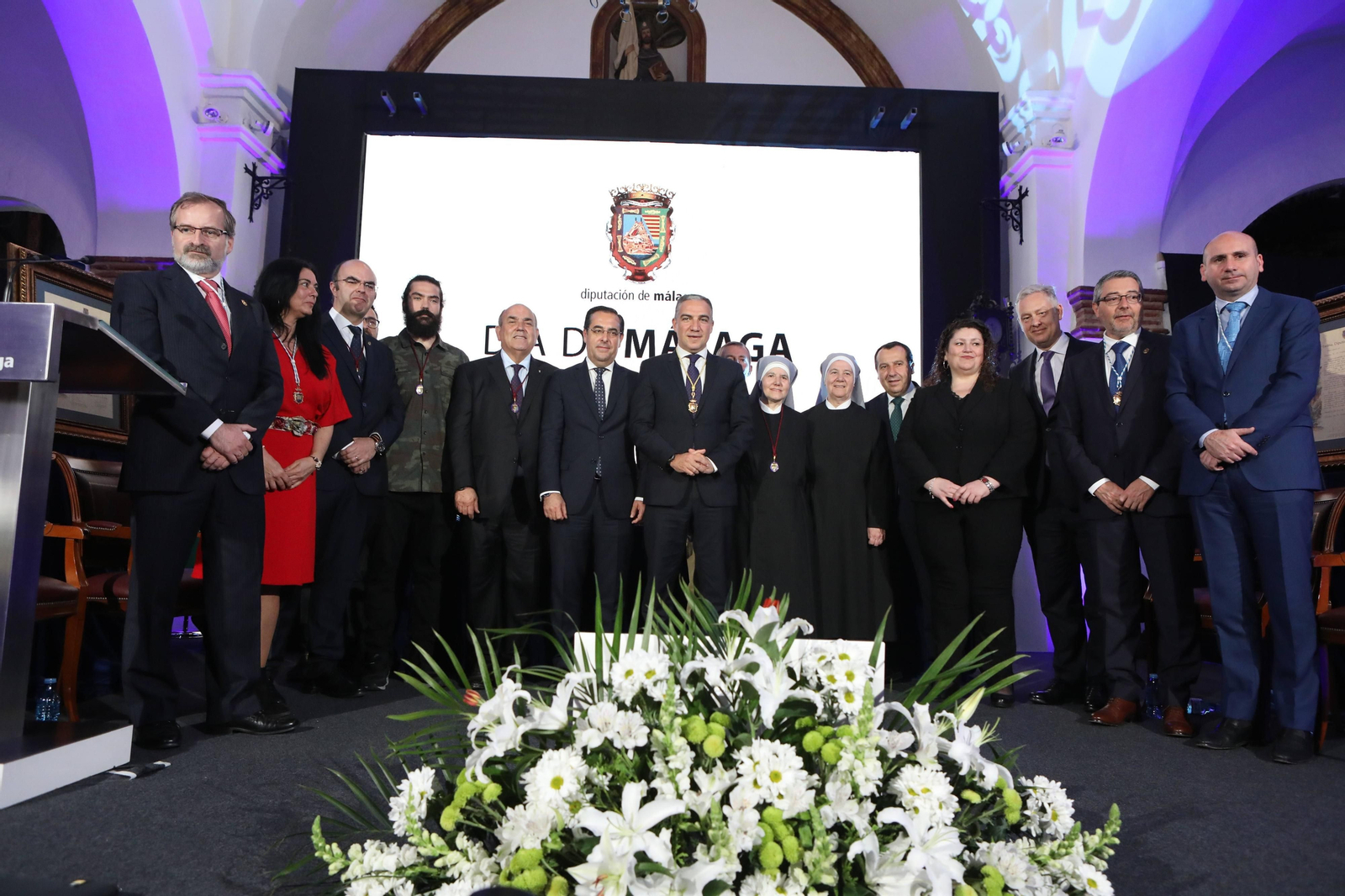 Foto de familia de los premiados junto a los representantes de diferentes instituciones políticas.