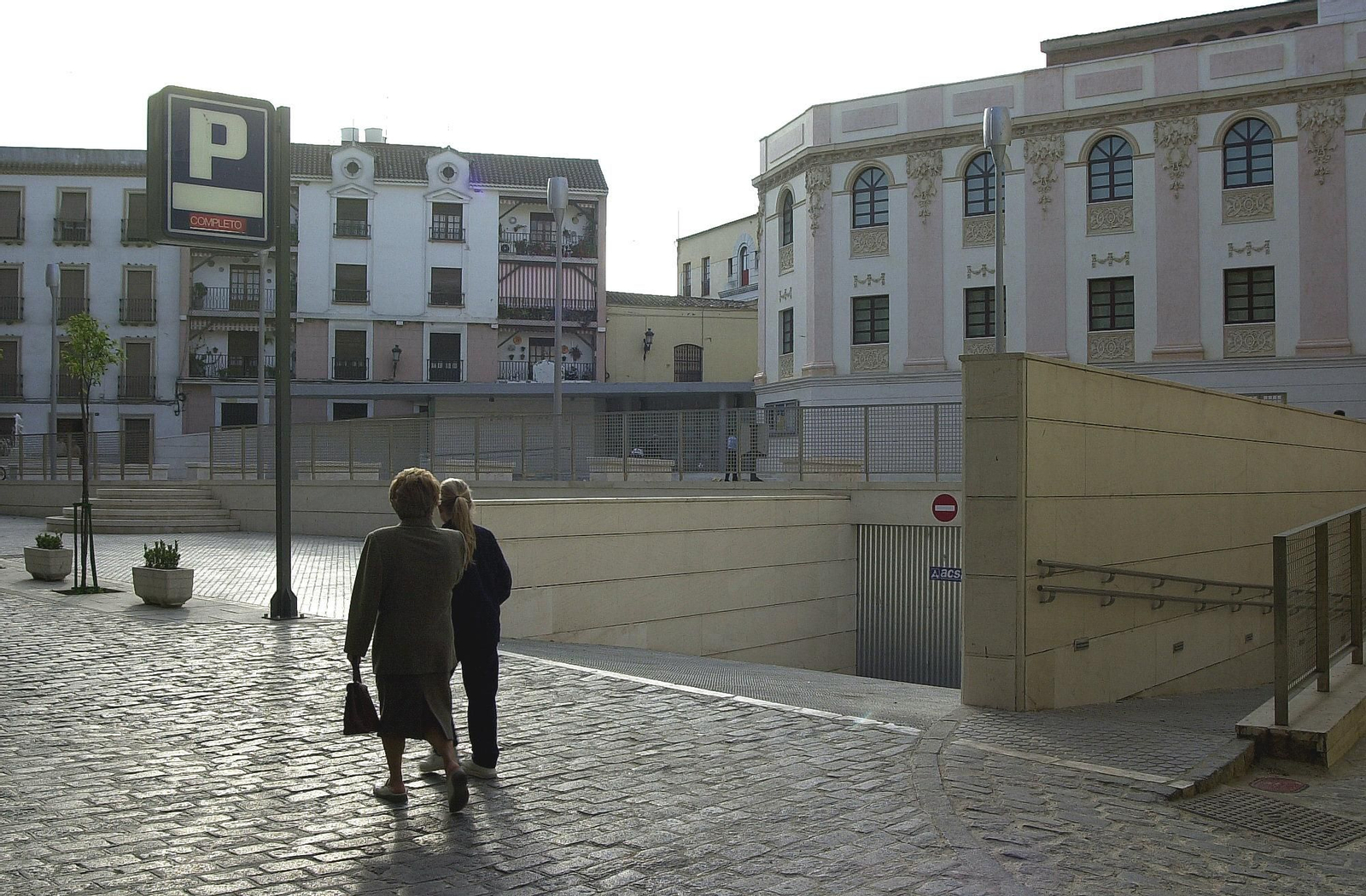 Dos mujeres pasan junto al acceso al parking de la plaza de la Rosa.