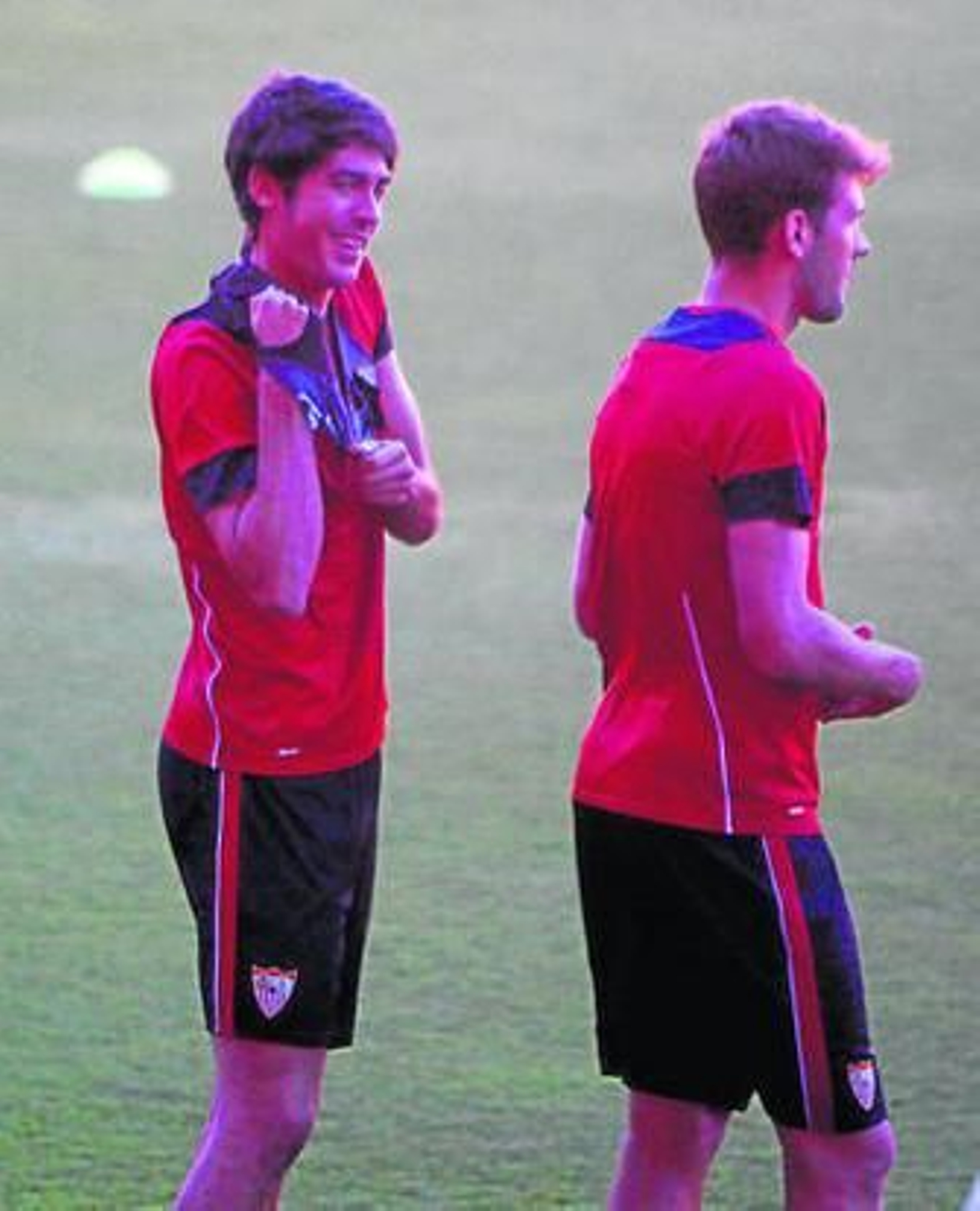 Carlos Fernández sonríe mientras se coloca un peto junto a Franco Vázquez.