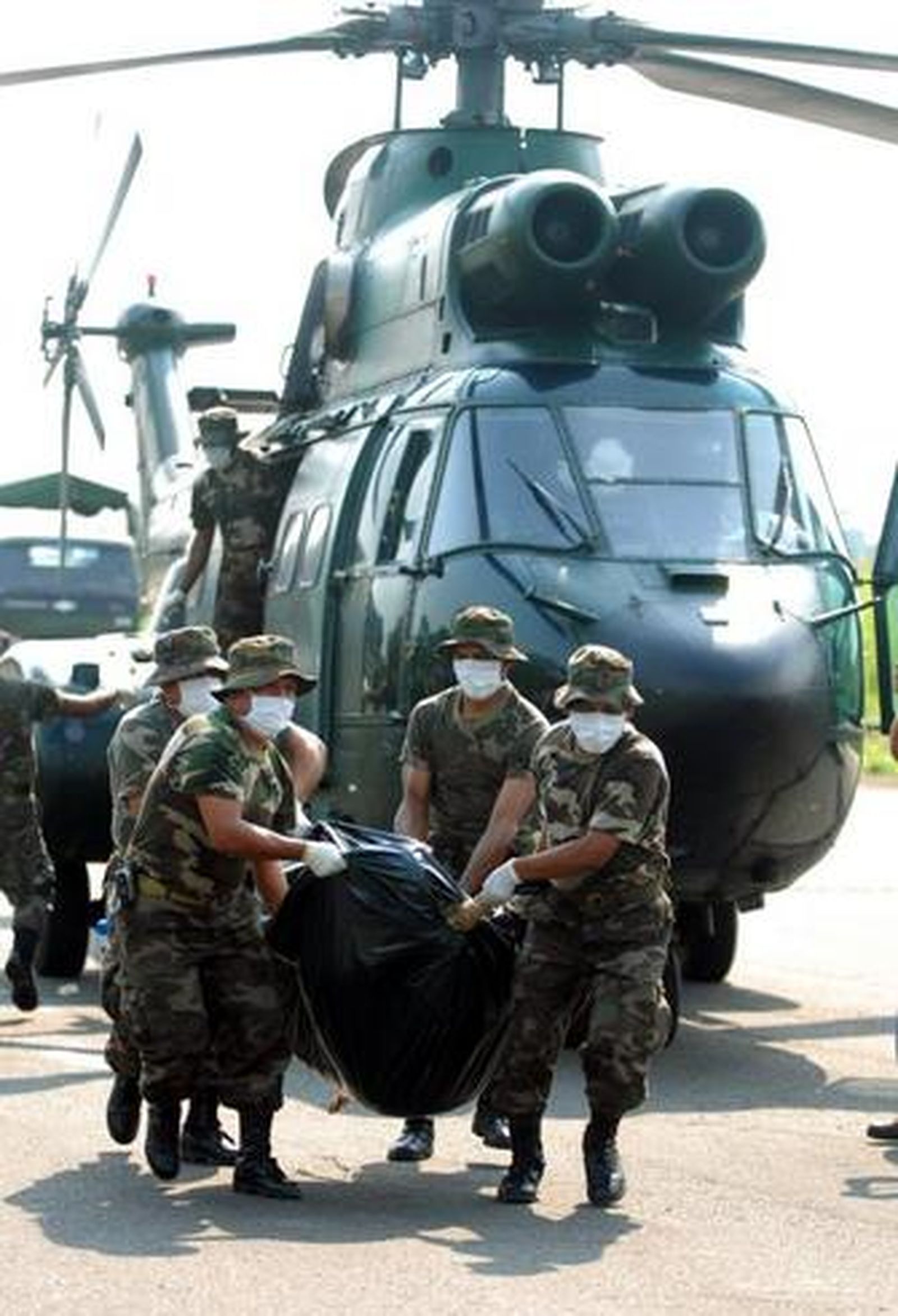 Militares ecuatorianos cargan los cuerpos de los rebeldes caídos en Ecuador.