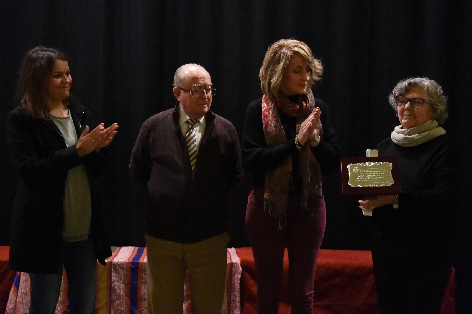 La directora del Aula, Eugenia Ferrera, recibe una placa ante la mirada de Pilar Pintor, Diego de Salas y Asunción García.