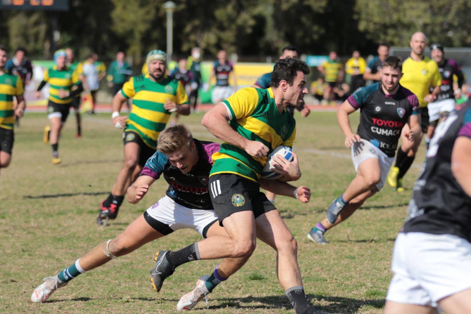 Un jugador del CRAP intenta progresar ante la oposición de los jugadores de C.R. Málaga.