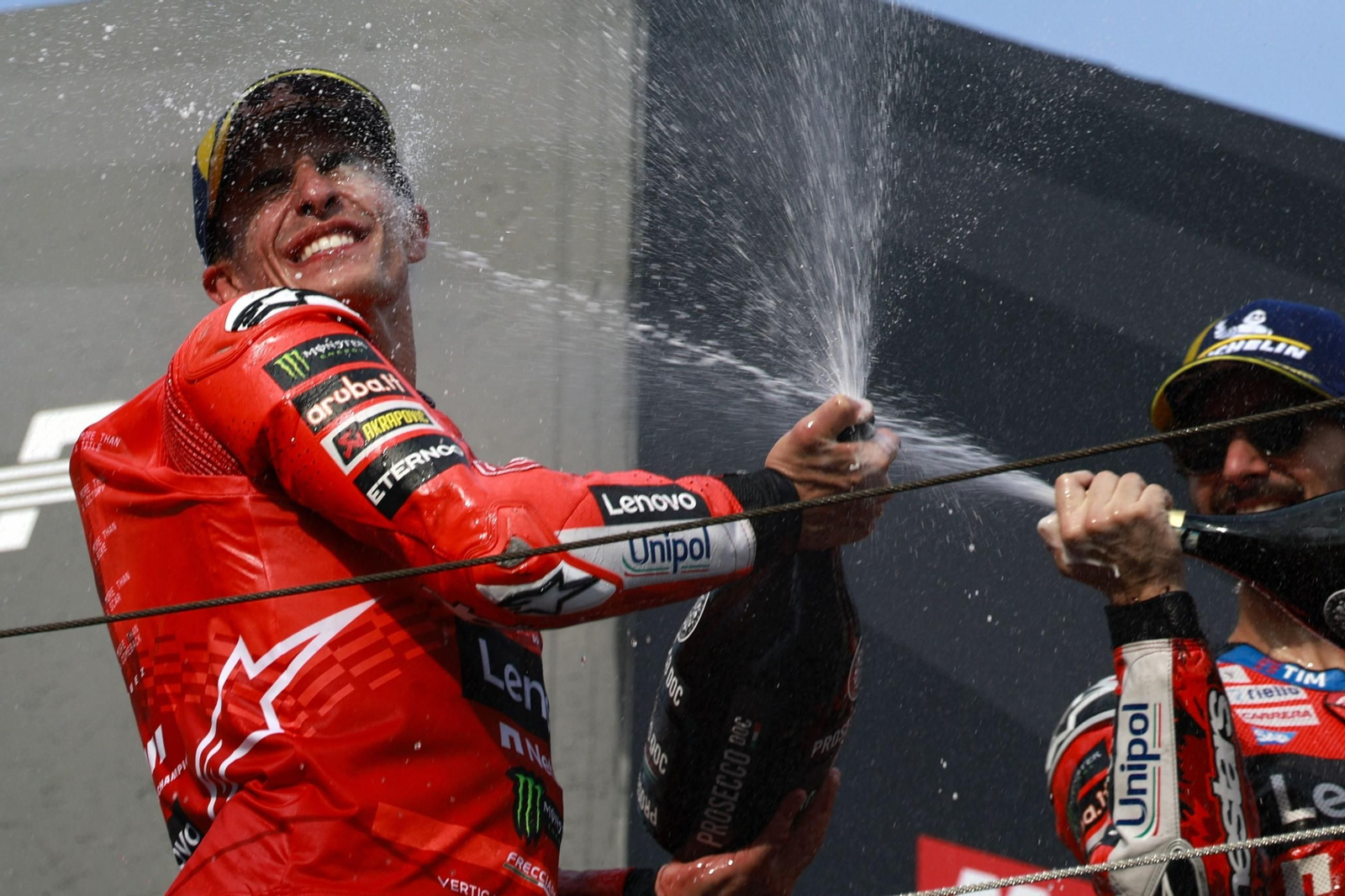 Marc Márquez recibe el champán en su rostro de Pecco Bagnaia.