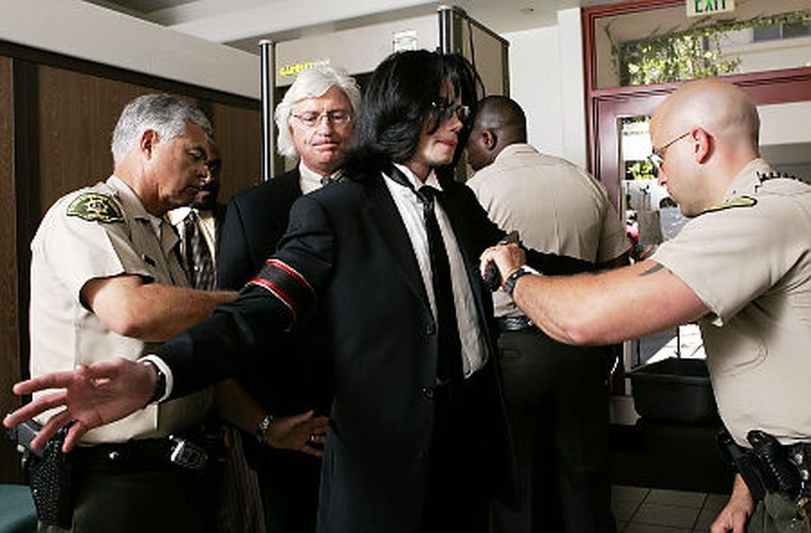 Michael Jackson es cacheado por la policía antes de entrar al juicio por abuso de menores que tuvo en 2005.