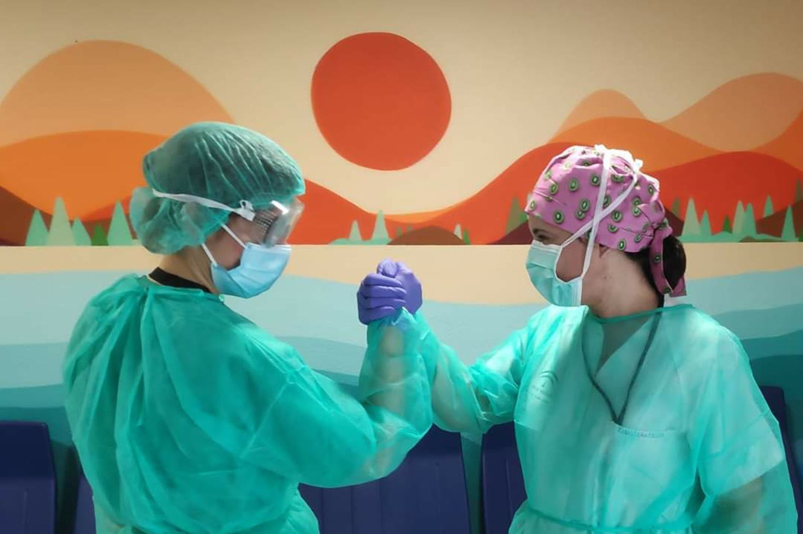 Dos enfermeras chocan sus manos en el hospital Juan Ramón Jiménez.