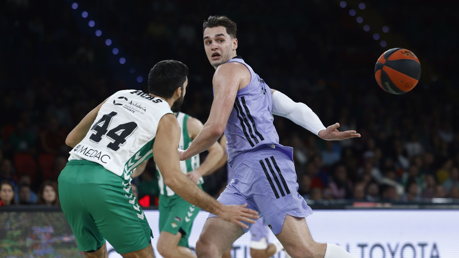 Hezonja da un pase por la espalda ante Pozas.