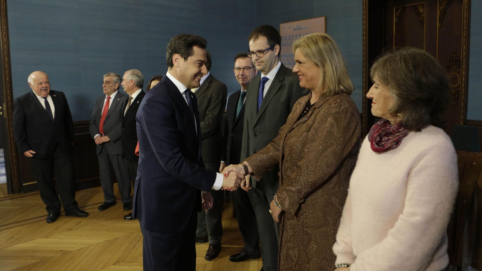 Juanma Moreno estrecha la mano de Lola Palomino, en un encuentro con la ONG Farmaceuticos sin Fronteras.