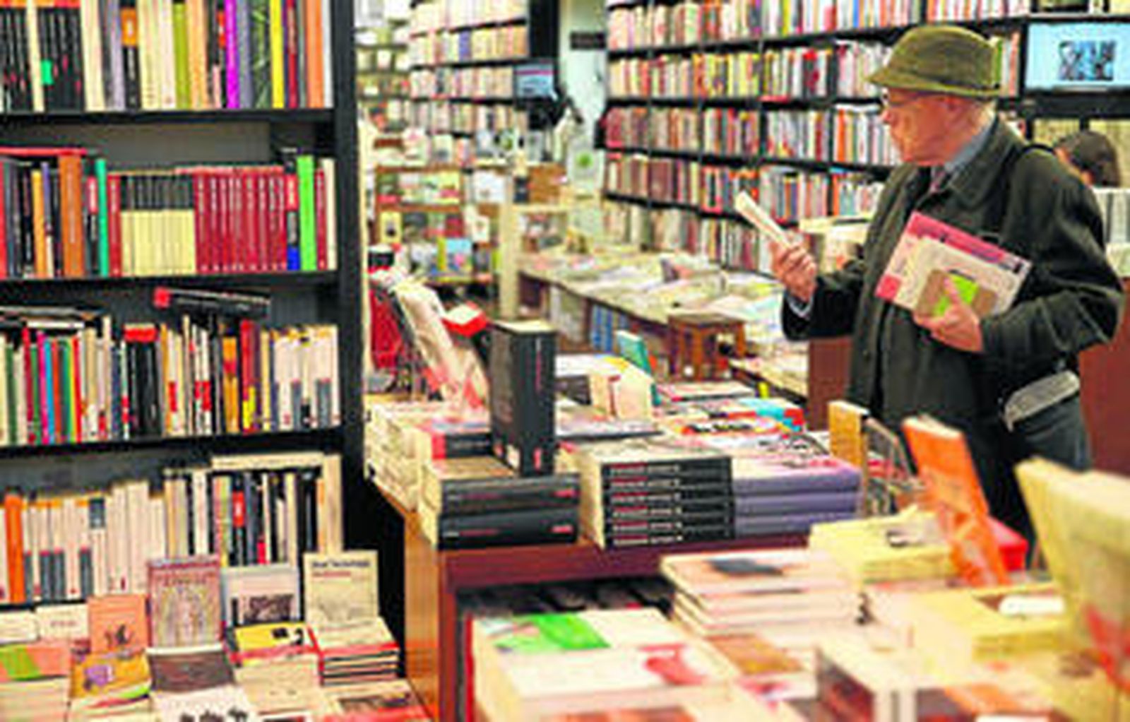 Un hombre ojea libros en una librería.