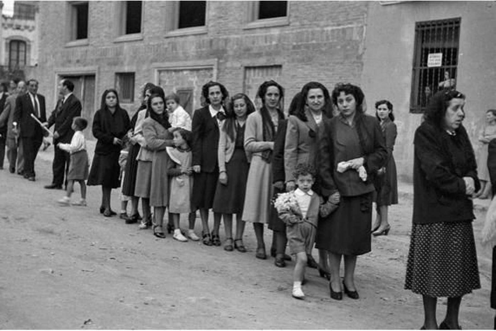 Mujeres haciendo cola para entrar en la Escuela de Apostolado y Formación Moral.