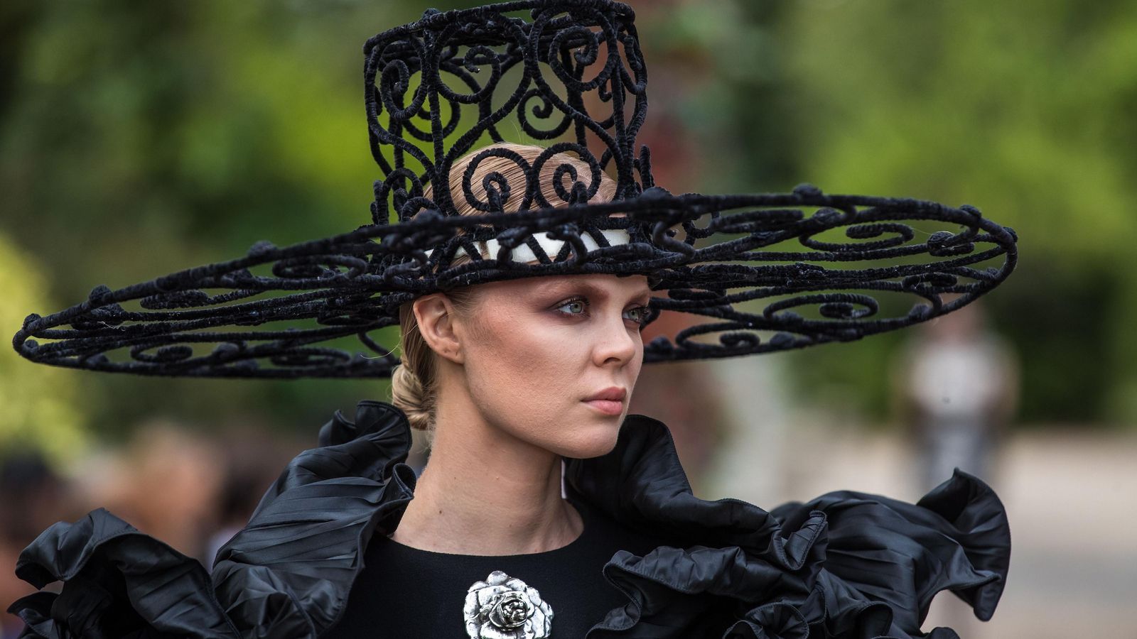 Una modelo luce un espectacular tocado en forma de sombrero.