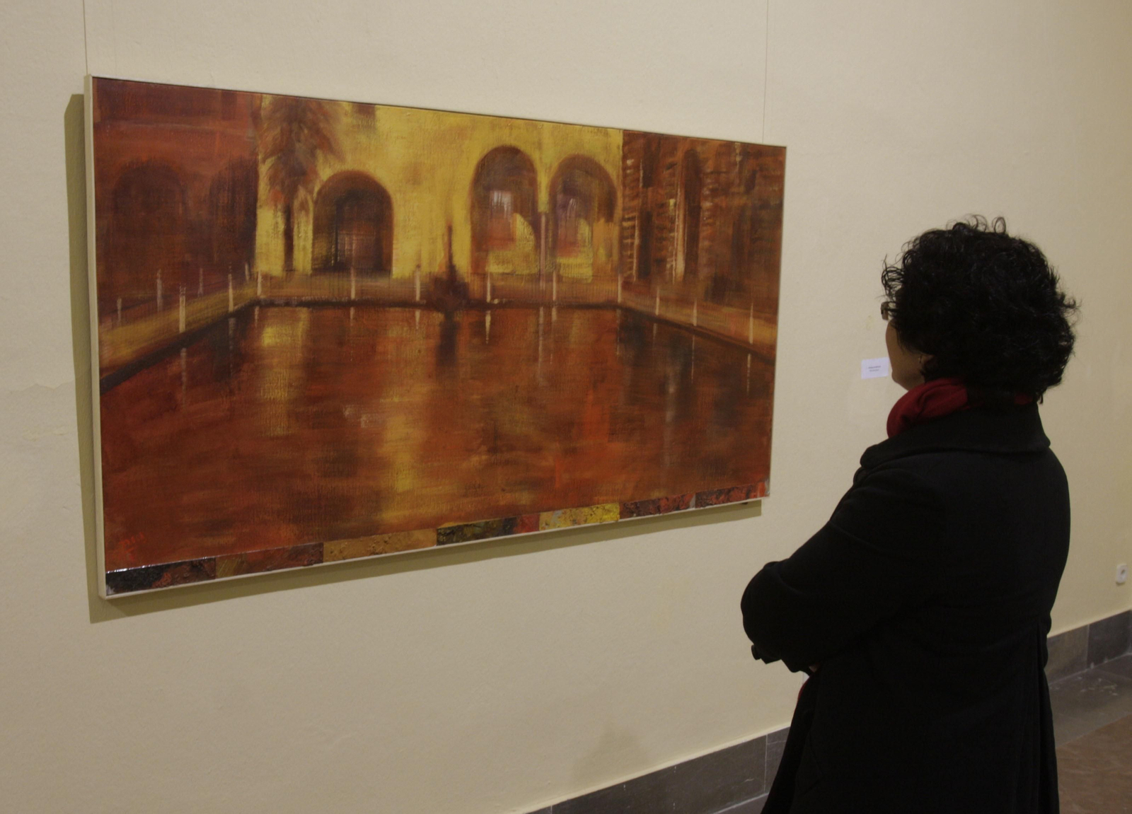 Una mujer contempla uno de los cuadros del pintor Paco Broca.