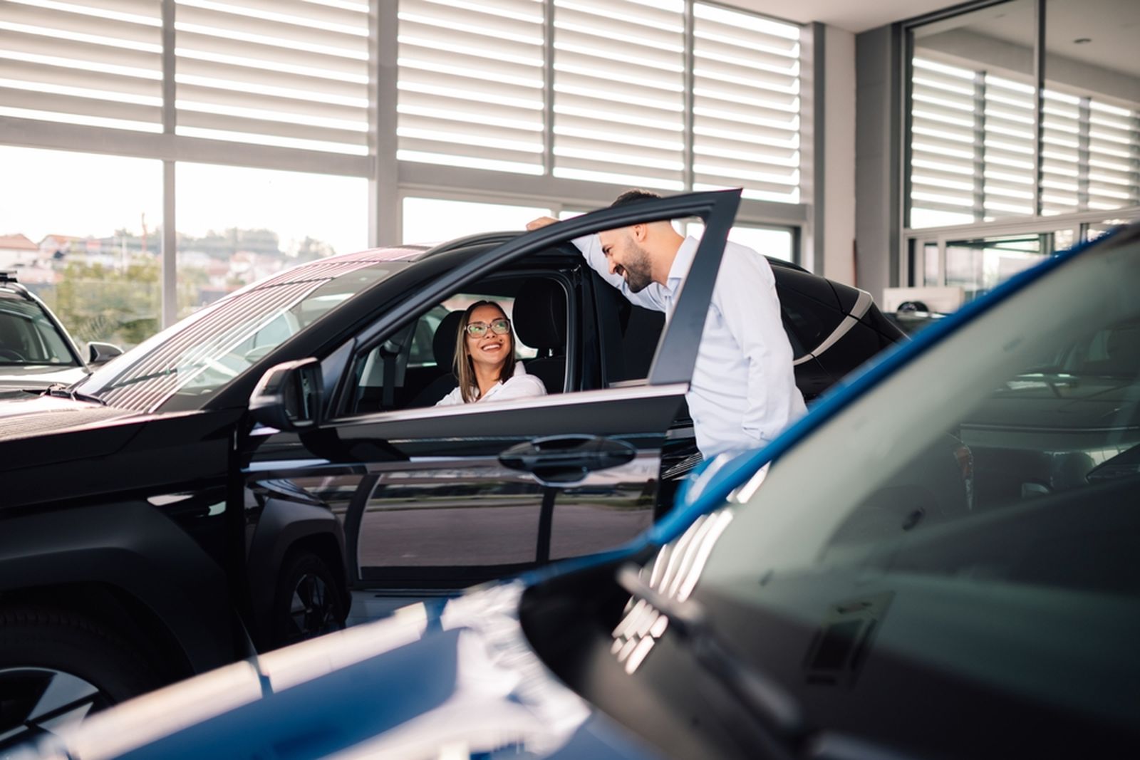 Dos personas compran un coche en un concesionario.