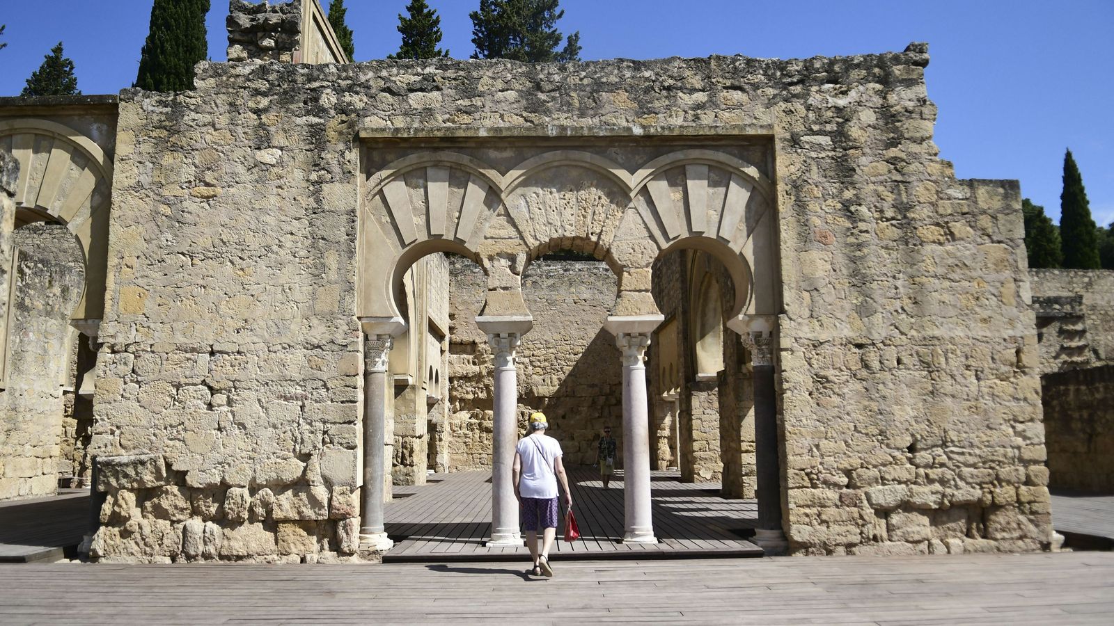 Una turista frente a una de las partes del Edificio Basilical Superior del yacimiento arqueológico.