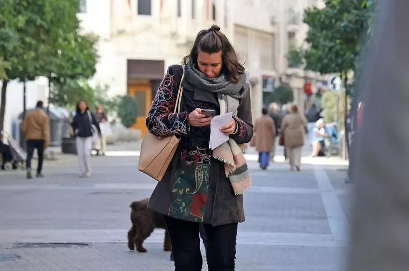 Una mujer utiliza su móvil mientras pasea. Una mujer utiliza su móvil mientras pasea.