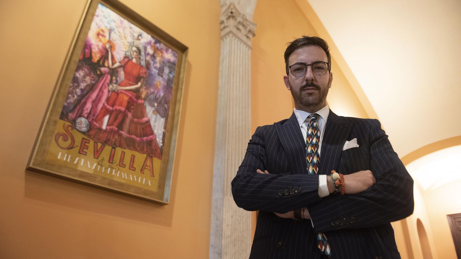 José Tomás Pérez Indiano junto al cartel que ilustra las Fiestas de Primavera de Sevilla.