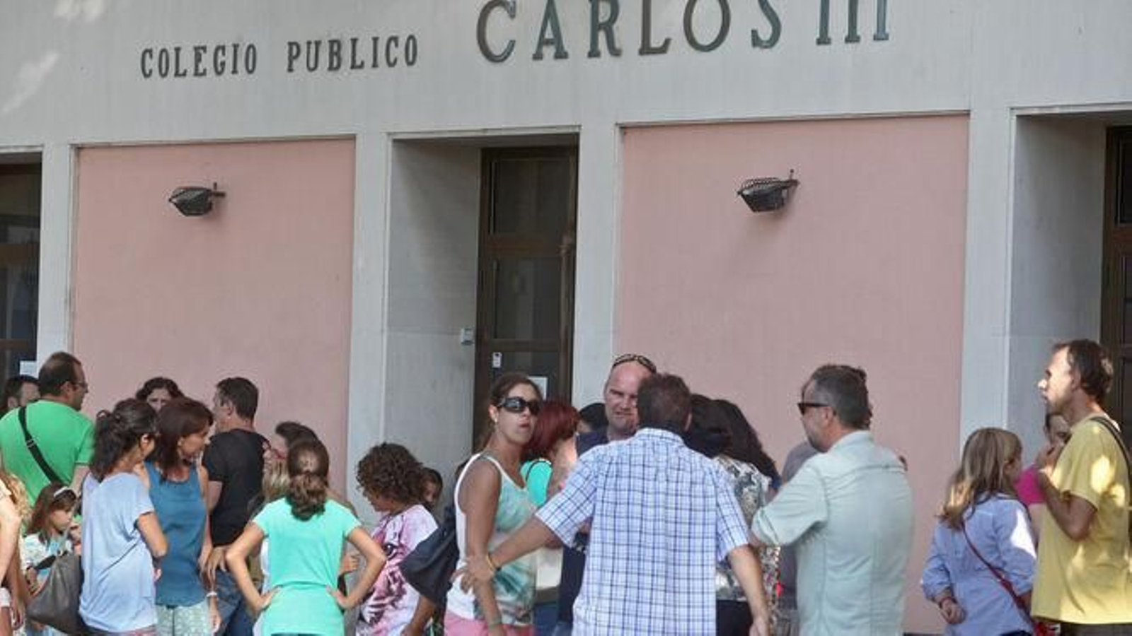 Alumnos, madres y padres, en la puerta de un colegio público en Cádiz.