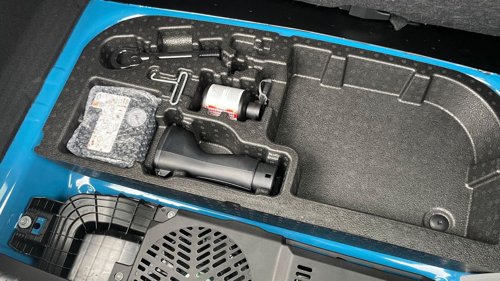 Levantado el suelo del maletero es accede a esta zona compartimentada donde pueden albergarse los cables de carga y en la que también se sitúa el kit de reparación de pinchazos o el adaptador del conector para la función V2L.