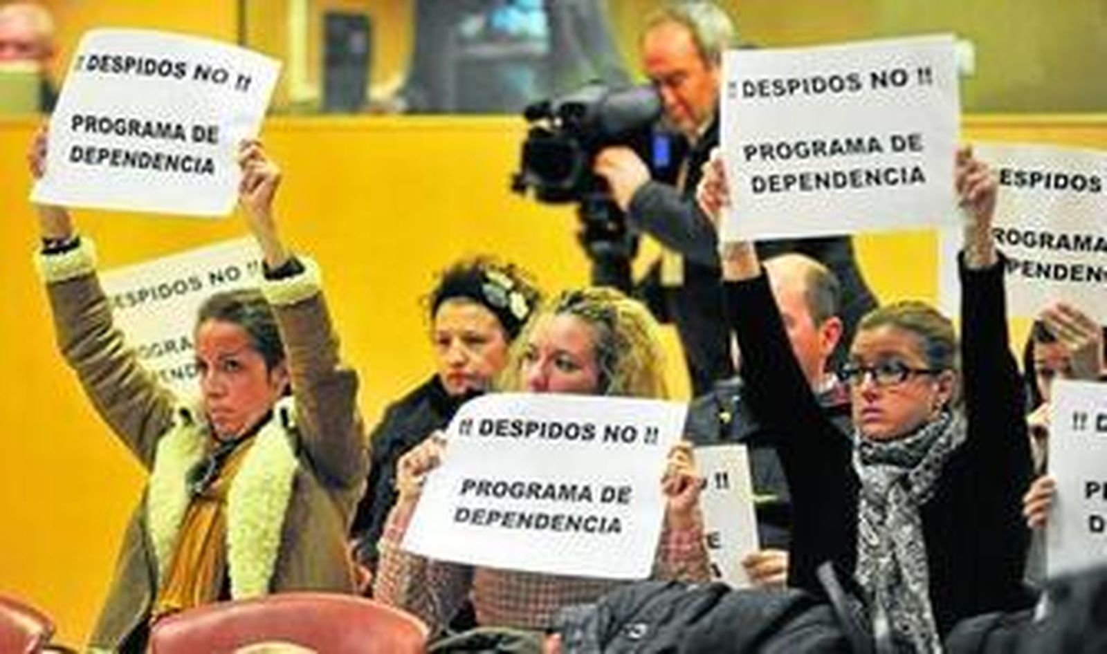 Parte de los trabajadores del programa de refuerzo de los servicios sociales, protestando, ayer, en el Pleno.