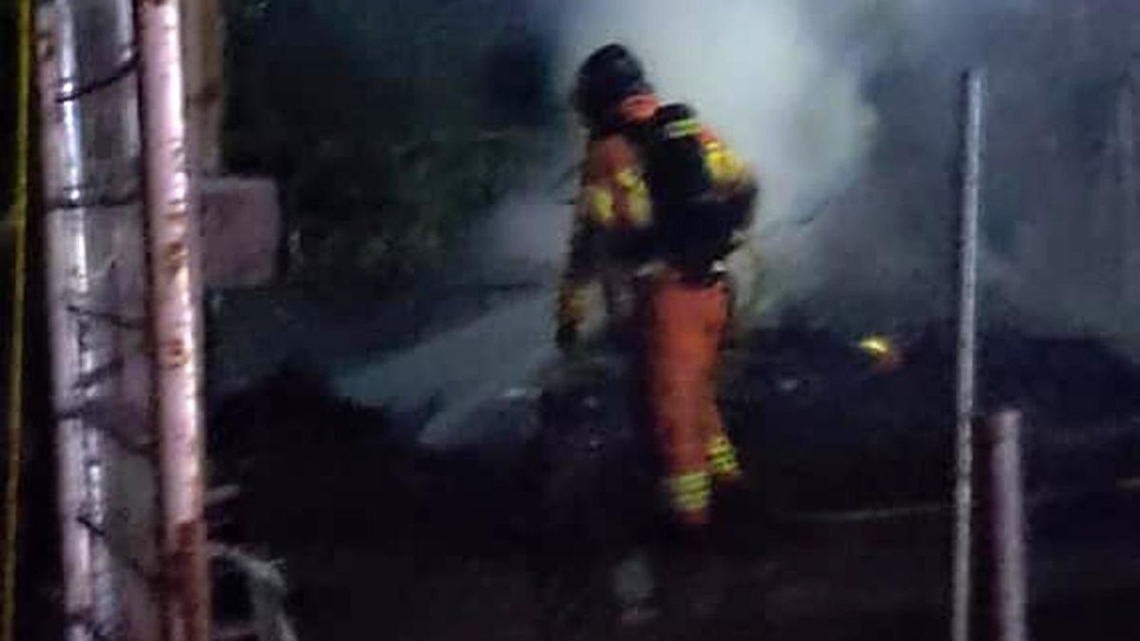 Uno de los bomberos actúa en el incendio en los asentamientos de Lepe.
