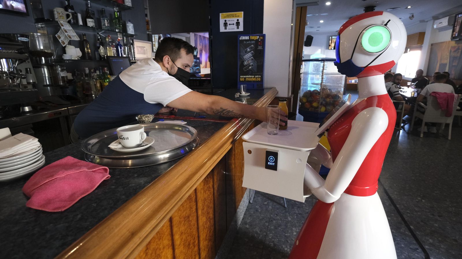 GInés hijo pone un zumo en la robot camarera.