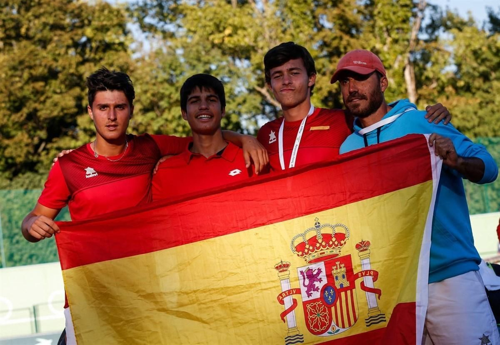 El tenista jerezano, junto a Carlos Alcaraz, Mario González y el capitán, David Ayuela, con la bandera de España.