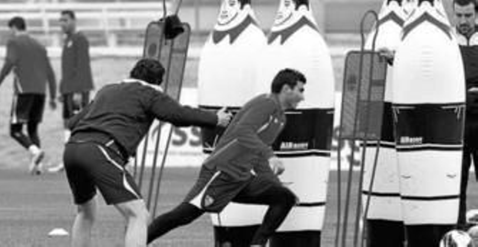 Unai Emery, con una pica, camina sobre el césped de la ciudad deportiva.