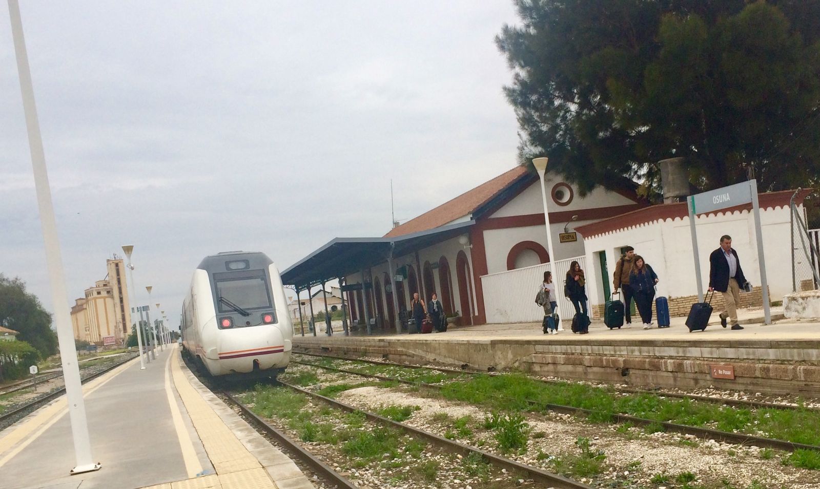 Viajeros en la estación de Osuna en el momento de transbordar del autobús al tren, porque la vía hasta Pedrera sigue cortada.