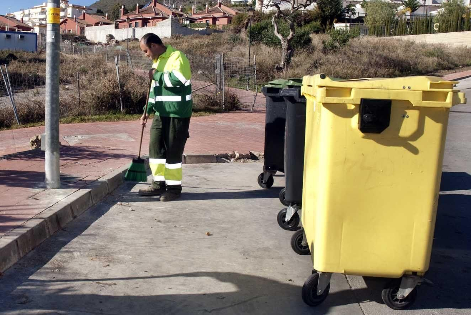 Un operario de la limpieza  de Benalmádena  barre una acera.