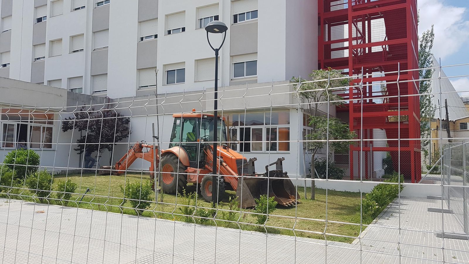 Una excavadora en una zona ajardinada de la residencia de Cruz Roja.