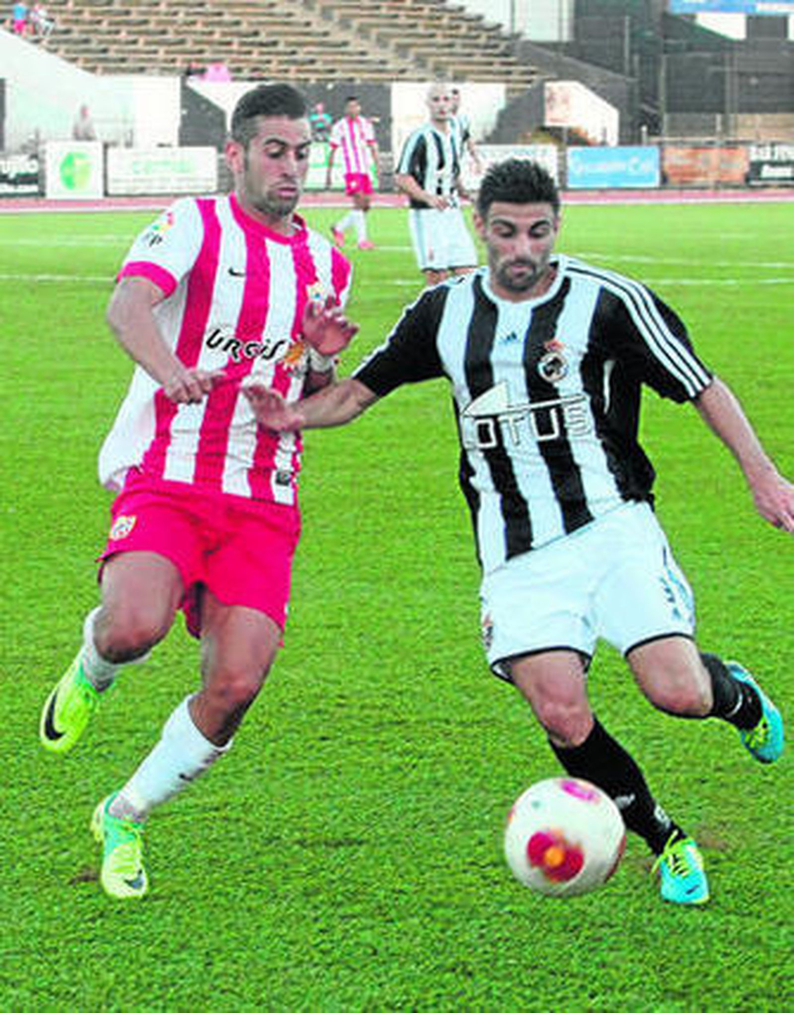 Javi Gallardo se dispone a centrar, obstaculizado por un rival.