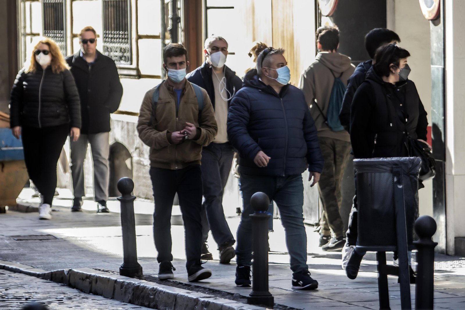 Gente con y sin mascarilla por las calles de Granada.