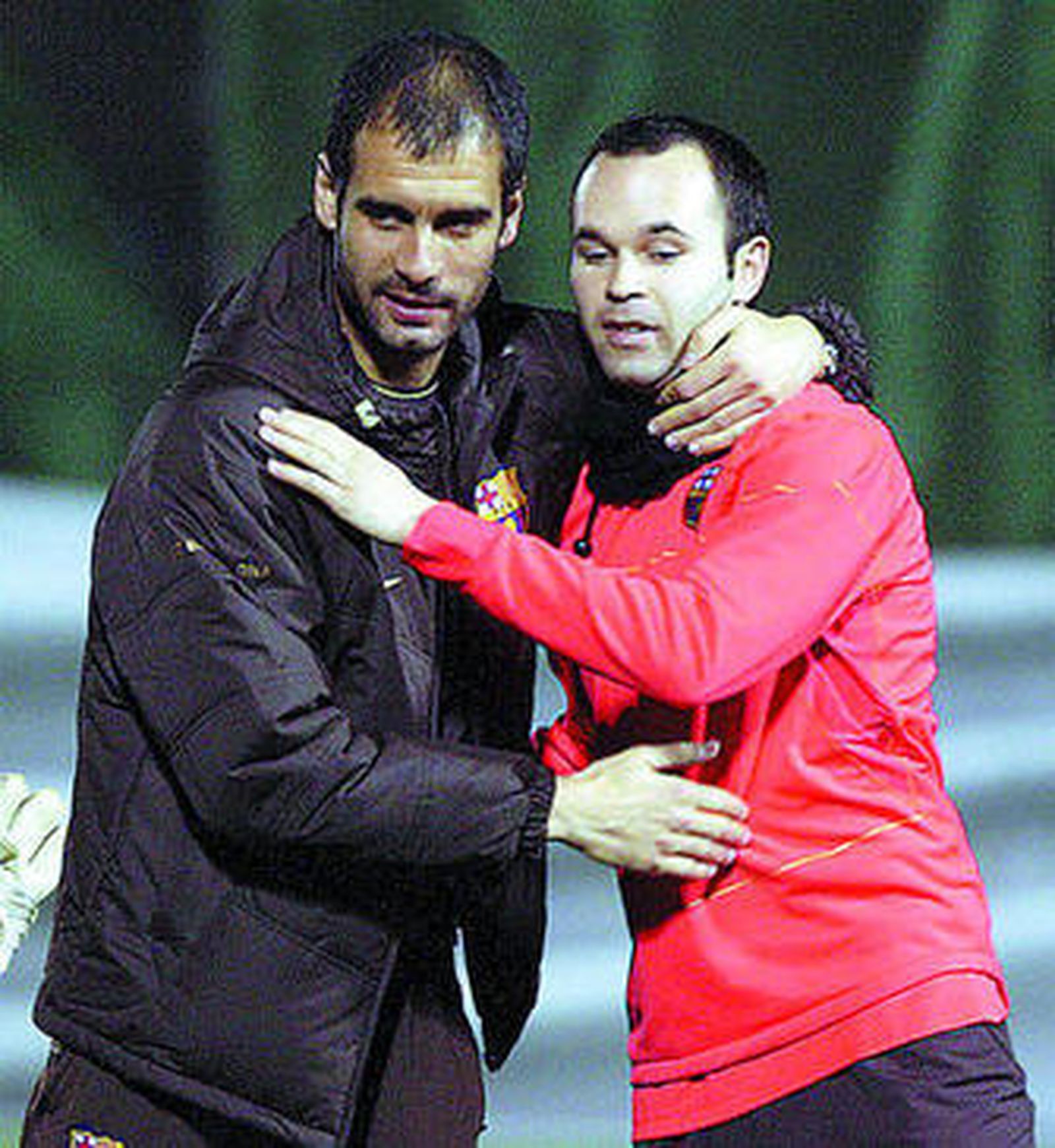 Guardiola se saluda con Iniesta, principal novedad barcelonista.