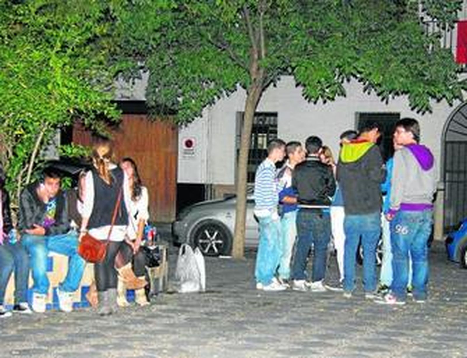 Un grupo de jóvenes haciendo 'botellona' en la plaza de los Refinadores, la noche del viernes.