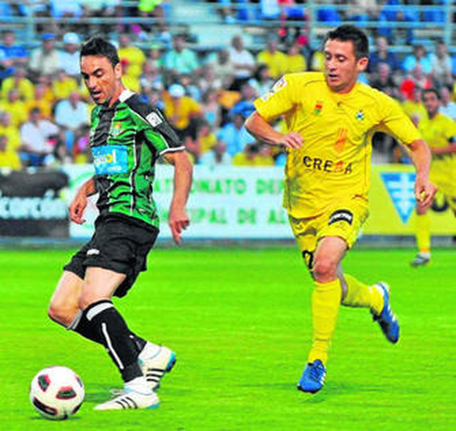 El bético Momo cubre la pelota ante la presión de un rival.